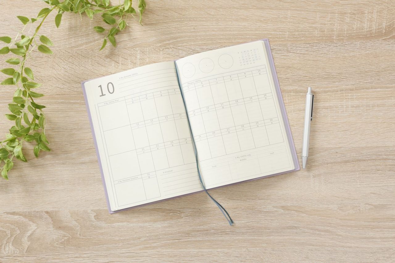木の机に開いた10thly Journalとペン